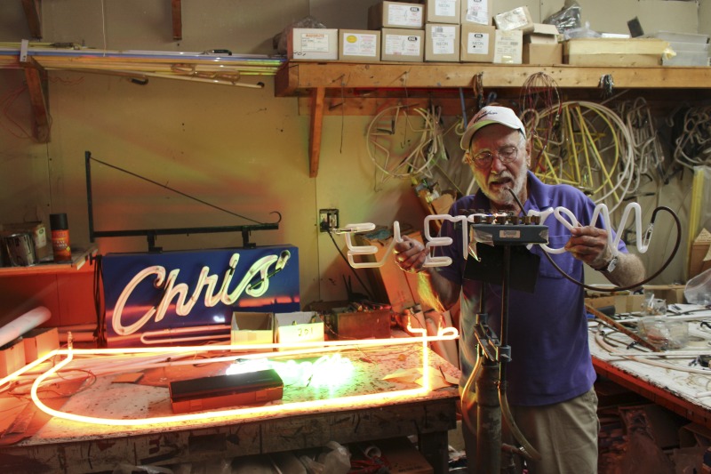 ["James L. Day (July 5, 1932-April 12, 2019) was the owner of JL Day Sign Company in St. Albans, WV. He made hand-bent neon signs for nearly 60 years and was one of the last hand tube benders in the Kanawha Valley.In 2018, the West Virginia Folklife Program worked with West Virginia Public Broadcasting to produce audio and video documentaries about Day. View them at https://wvfolklife.org/2018/09/04/st-albans-artisan-has-been-making-neon-signs-by-hand-for-five-decades-a-profile-of-james-l-day/Video: https://www.youtube.com/watch?v=cCe99a7ke50&feature=emb_titleAudio: https://soundcloud.com/wvpublicnews/wva-artisan-has-been-making-neon-signs-by-hand-for-five-decadesRead Days obituary here: https://www.dignitymemorial.com/obituaries/saint-albans-wv/james-day-8250954"]%