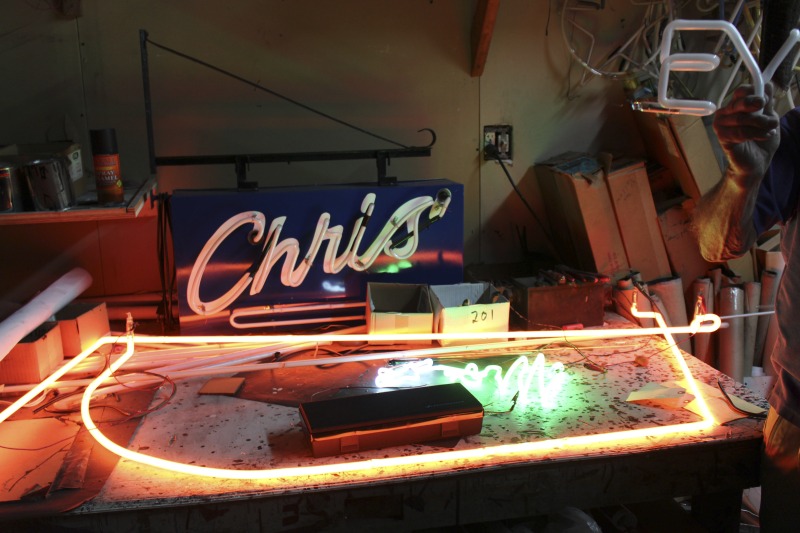 ["James L. Day (July 5, 1932-April 12, 2019) was the owner of JL Day Sign Company in St. Albans, WV. He made hand-bent neon signs for nearly 60 years and was one of the last hand tube benders in the Kanawha Valley.In 2018, the West Virginia Folklife Program worked with West Virginia Public Broadcasting to produce audio and video documentaries about Day. View them at https://wvfolklife.org/2018/09/04/st-albans-artisan-has-been-making-neon-signs-by-hand-for-five-decades-a-profile-of-james-l-day/Video: https://www.youtube.com/watch?v=cCe99a7ke50&feature=emb_titleAudio: https://soundcloud.com/wvpublicnews/wva-artisan-has-been-making-neon-signs-by-hand-for-five-decadesRead Days obituary here: https://www.dignitymemorial.com/obituaries/saint-albans-wv/james-day-8250954"]%