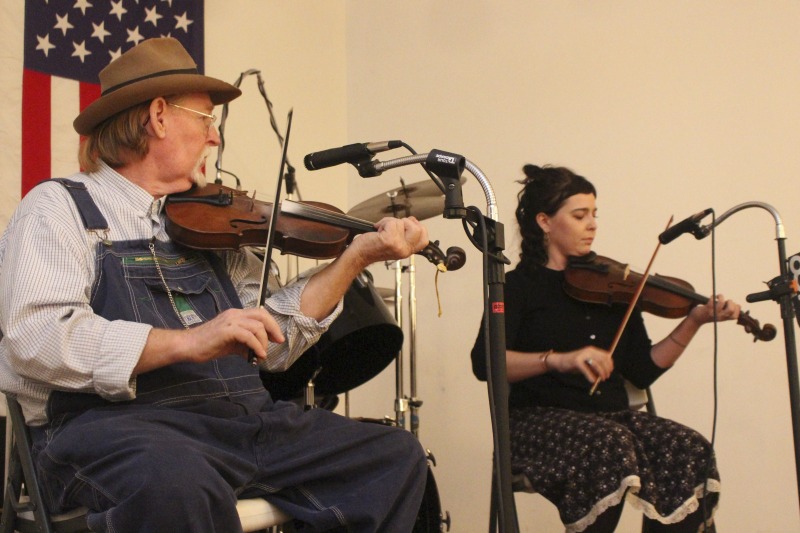 ["John D. Morris of Ivydale led an apprenticeship in old-time fiddle and stories of Clay County with Jen Iskow of Thomas as part of the 2018 West Virginia Folklife Apprenticeship Program, supported in part by the National Endowment for the Arts. John D. MorrisBorn in Ivydale, Clay County, into a family steeped in traditional music, David and John Morris learned from family and neighbors, including banjo player Jenes Cottrell and fiddler French Carpenter. After David returned from Vietnam in 1968, the brothers began organizing musical get-togethers and, in 1969, held the first Morris Family Old-Time Music Festival that same year. The festival became a major traditional music event in Clay County and filmmaker Bob Gates documented the 1972 festival in his film The Morris Family Old-Time Music Festival.Members of The Morris Brothers band included Pocahontas County old-time banjo player Dwight Diller and the late North Carolina harmonica player John Martin. Playing a mix of old-time, bluegrass, and country styles, including some of Davids original music, the group played together through the mid-70s, releasing an LP in the late 60s, Music As We Learned It, and two live shows on eight-track tapes. John, a traditional fiddler, and David, a singer, songwriter, and guitarist, were involved in union and environmental activities from the late 1960s through the 1970s. They were also instrumental in establishing the first Vandalia Gathering at the Cultural Center in 1977.The Morris Brothers music was featured in Barbara Kopples 1976 film Harlan County, USA. David, who passed away in 2016, contributed music to Kopples 2015 film about Vietnam vets, Shelter.John lives in Ivydale and plays fiddle at music events across West Virginia. He is a rich source of information about the history of old-time music in central West Virginia, and one of the few native fiddlers of his generation to continue the older style of playing.Morris was awarded the National Endowment for the Arts National Heritage Fellowship, the nations highest honor in the folk and traditional arts, in 2020.Jen IskowJen Iskow is an artist, designer, musician, and community organizer based in Thomas, West Virginia. Born and raised in Rockville, Maryland, Jen grew up learning to play blues and punk music. It wasnt until she moved to Morgantown in 2009 for college that she was introduced to old-time music at the weekly Brew Pub jam hosted by Stewed Mulligan. After graduating from West Virginia University, she finally settled in Elkins, West Virginia and accepted a position as the Marketing Coordinator for the Augusta Heritage Center. Suddenly being surrounded by so many talented traditional artists, Jen was immersed into the music and inspired to learn to play fiddle. After studying under talented fiddlers such as Scott Prouty, Erynn Marshall, Jesse Wells, Ben Townsend, John Harrod, and more, Jen met John Morris at his house in Ivydale, and the rest is historySee our feature on Morris apprenticeship with Iskow here: https://wvfolklife.org/2018/11/09/2018-master-artist-apprentice-feature-john-morris-jen-iskow-old-time-fiddling-and-stories-of-clay-county/"]%