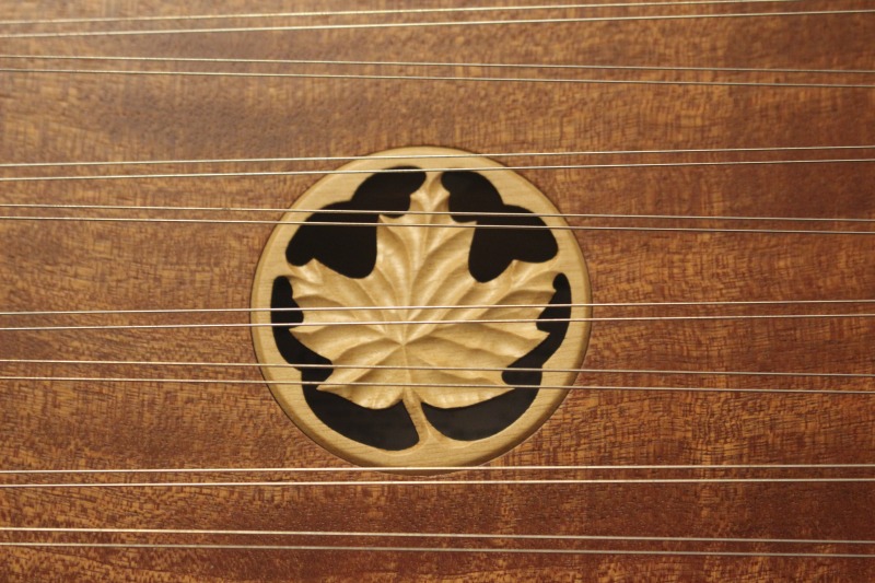 ["Sound hole of wooden hammer dulcimer made by Sam Rizzetta. Rizzetta is a dulcimer designer, builder, and musician who moved to West Virginia in the early 1970s. He was a member of the string band Trapezoid and founded the hammer dulcimer playing classes at the Augusta Heritage Center at Davis & Elkins College. He has built dulcimers for musicians including John McCutcheon, Guy Carawan, and Sam Herrmann. Rizzetta now collaborates with the Dusty Strings Company who build hammer dulcimers based on his designs. He lives with his wife Carrie Rizzetta in Berkeley County, WV. He was photographed in his home workshop."]%