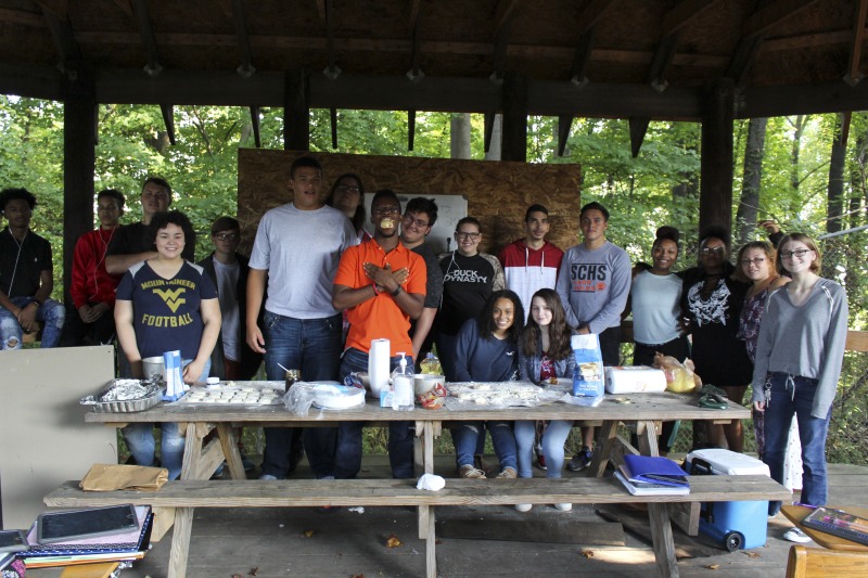 ["On September 21, 2017, old-time musician and writer Pete Koskys Appalachian Studies class at South Charleston High School made biscuits in a cast iron Dutch oven over a charcoal fire at the ROTC picnic shelter on the school campus. Kosky invited state folklorist Emily Hilliard to the class."]%