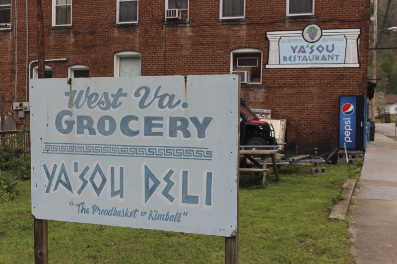 Yasou Restaurant is a Greek restaurant and grocery in Kimball in McDowell County. The restaurant has been owned and operated since 2003 by Markella Gianato whose maternal grandfather John Genadopoulus and father Adamantios Tommy Balasis opened The West Virginia Grocery in the same location in 1947. Genadopolous bought the building from A.P. Wood, whose name still remains on the storefront. The Grocery shut down in 2001 after the July flood all but destroyed the building.Today the restaurant serves as a hub in the Kimball community. Menu offerings include gyros, Greek-style spaghetti and meatballs, spanakopita, Greek salad, pastitsio (a Greek pasta with meat and bchamel), dolmades (stuffed grape leaves), and saganaki (pan-seared Greek cheese).State folklorist Emily Hilliard interviewed Gianato about her family history, foodways, and the business on April 27, 2016, but the interview was lost when Folklife Program equipment was stolen. Gianatos Our History statement on the Yasou website:On February 7, 1947, the Greek-American families of John Genadopoulos and Adamantios Tommy Balasis and Mary Balasis purchased the A.P. Wood Grocery.  Though the store was renamed the West Virginia Grocery, the name A.P. Wood remains etched in beautiful stained glass over the door at present day YaSou. From that time until the devasting flood of July 2001, the family kept the grocery in operation.  Ten months later, a second major flood hit the town within days of the business being reopened.  Despite this major setback, we were determined to move forward and reopen the business. Having my own restaurant was a lifelong dream, and on February 7, 2003, with the help of my mother Mary Balasis, my brothers John and Mathew, my husband Jimmy Joe, my son Adam, my mother-in-law Mary Verduce Gianato and the Grace of God, that dream became a reality with the opening of YaSou Restaurant.   I am immensely proud of the success that I have achieved.  I offer home-cooked meals, daily specials, and Greek cuisine along with many sandwich choices.  Most of the recipes I have used have been handed down to me from my mother and grandmother.  My love for the restaurant business came from my first job at the Virginian Restaurant in Pearisburg, Virginia, working under the guiding hands of, in my opinion, two of the greatest chefs, uncles and mentors, Mike and George Genadopoulos.  It was my days at the Virginian that made me realize I would someday like to become a great chef.  I strive for this every day. This has allowed me to meet many wonderful people who have stopped in along the way, as well as many local regulars who come in and make my day complete.  We hope to serve you for many years to come. Everyone that comes here, even for one time, becomes a part of the labyrinth of my life and will always be part of the memories here.  I want my guests to feel at home and comfortable when that are here.  If you have any concerns or requests, please feel free to ask.                                                             ---MarkellaRead more on the Yasou website: https://yasourestaurant-restaurant.business.site/